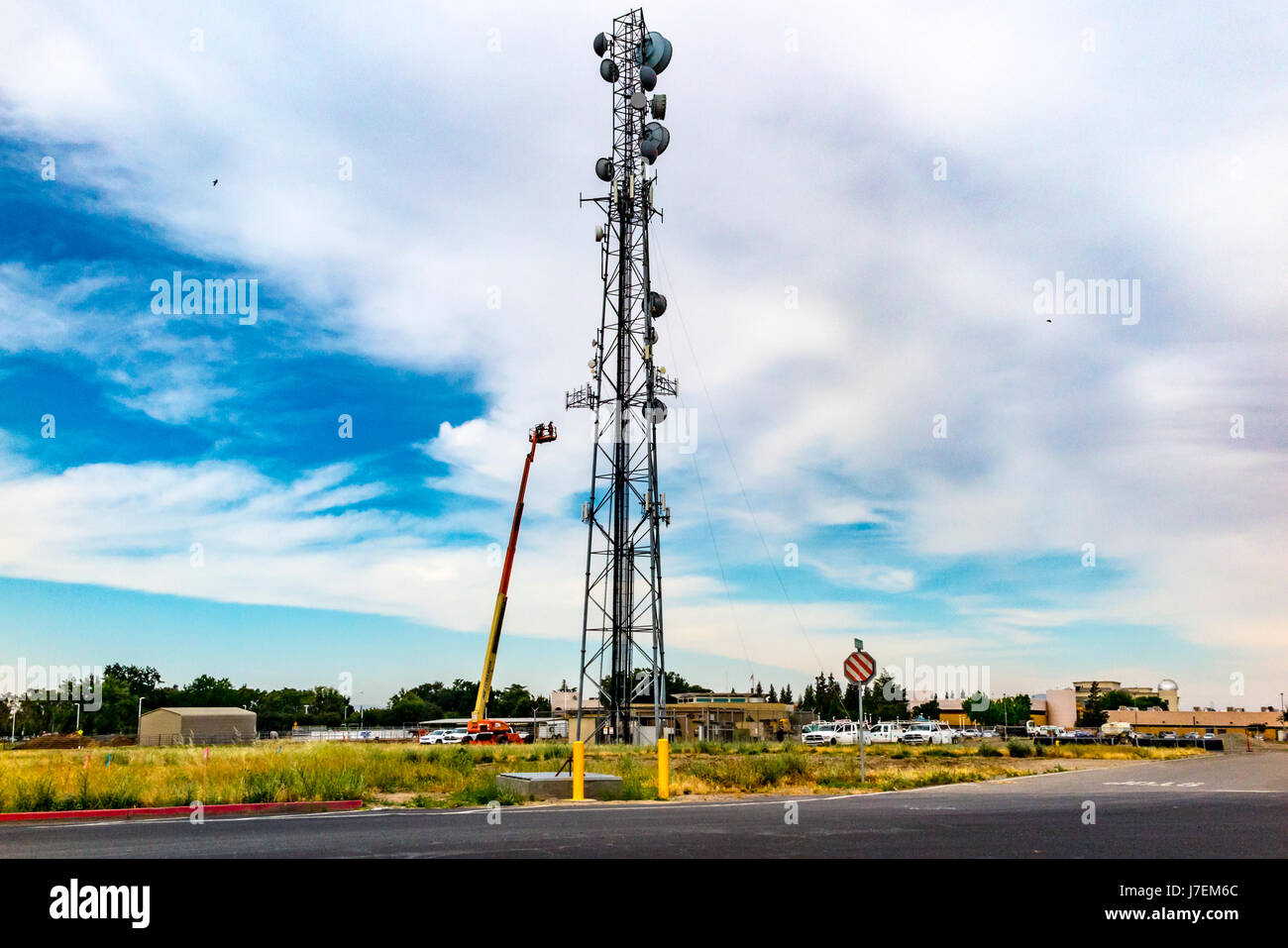 Workers performing tasks on a cell tower in MOdesto California Stock