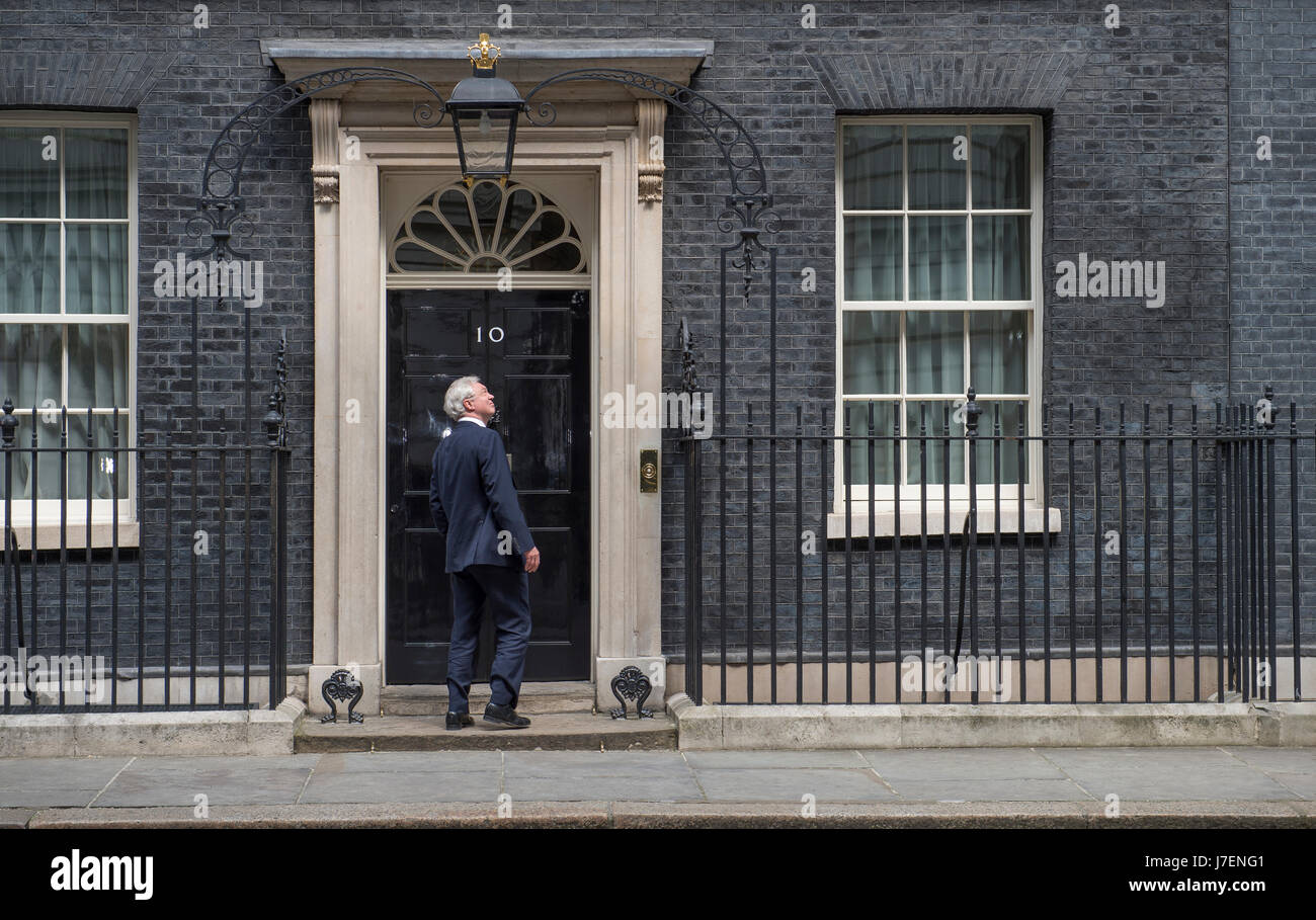 Downing Street, London, UK. 24th May 2017. Union flags fly at half-mast over 10 & 11 Downing Street after the Manchester terrorist outrage. Brexit Minister David Davis arrives and looks up at a helicopter from the front door of No 10. Credit: Malcolm Park editorial/Alamy Live News. Stock Photo