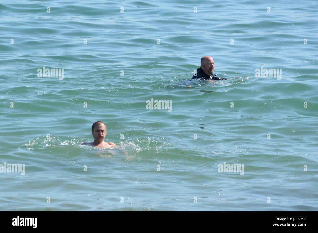Marazion, Cornwall, UK. 24th May 2017. UK Weather. After a foggy day yesterday, the sun finally shone over Cornwall today. These two chaps went for a swim at Marazion, although it looks like the water was still a bit chilly. Credit: cwallpix/Alamy Live News Stock Photo