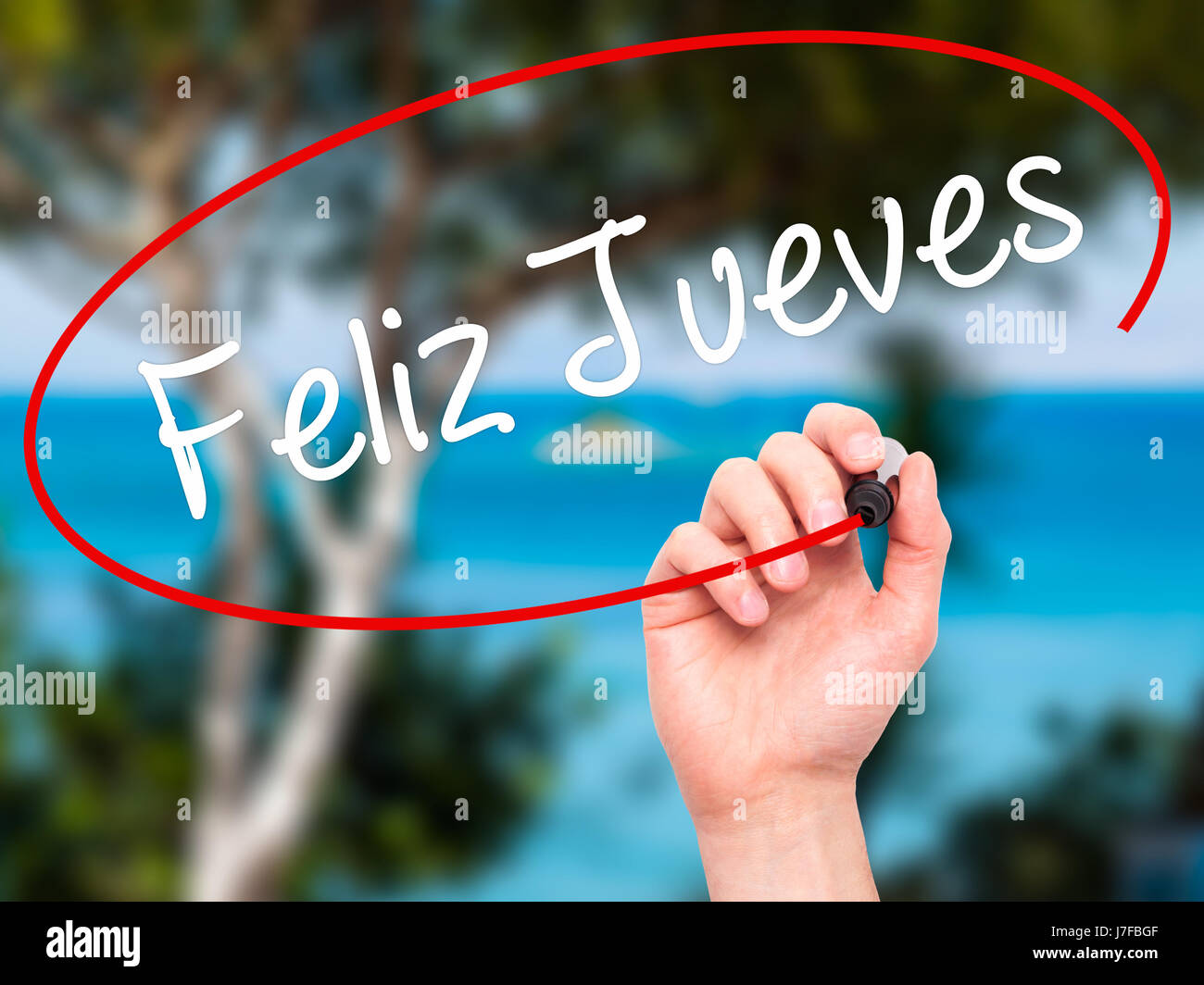 Man Hand writing Feliz Jueves (Happy Thursday In Spanish) with black marker on visual screen