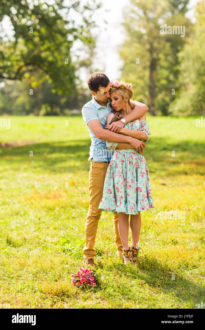 Couple embracing on the countryside. Young romantic man and woman standing and hugging each other with tenderness on nature. Young love concept Stock Photo