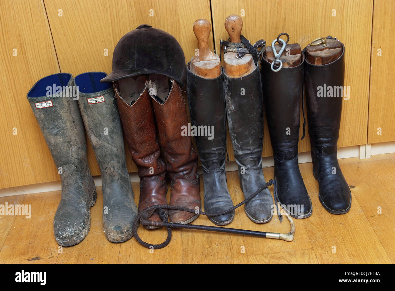 A line of boots including Hunter wellingtons and riding boots, whip and ...