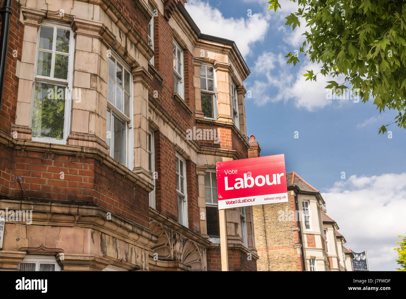 London, England - May 2017:A Vote Labour Sign poster with victorian houses in the background on a local street in London supporting the labour party f Stock Photo