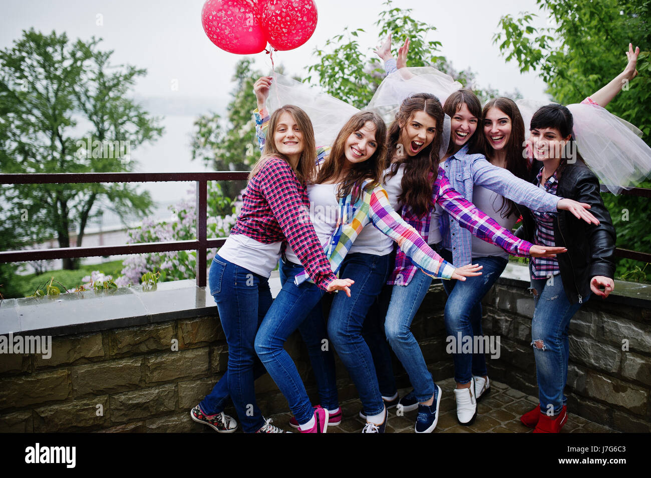 Group of six girls having fun at hen party, with balloons 