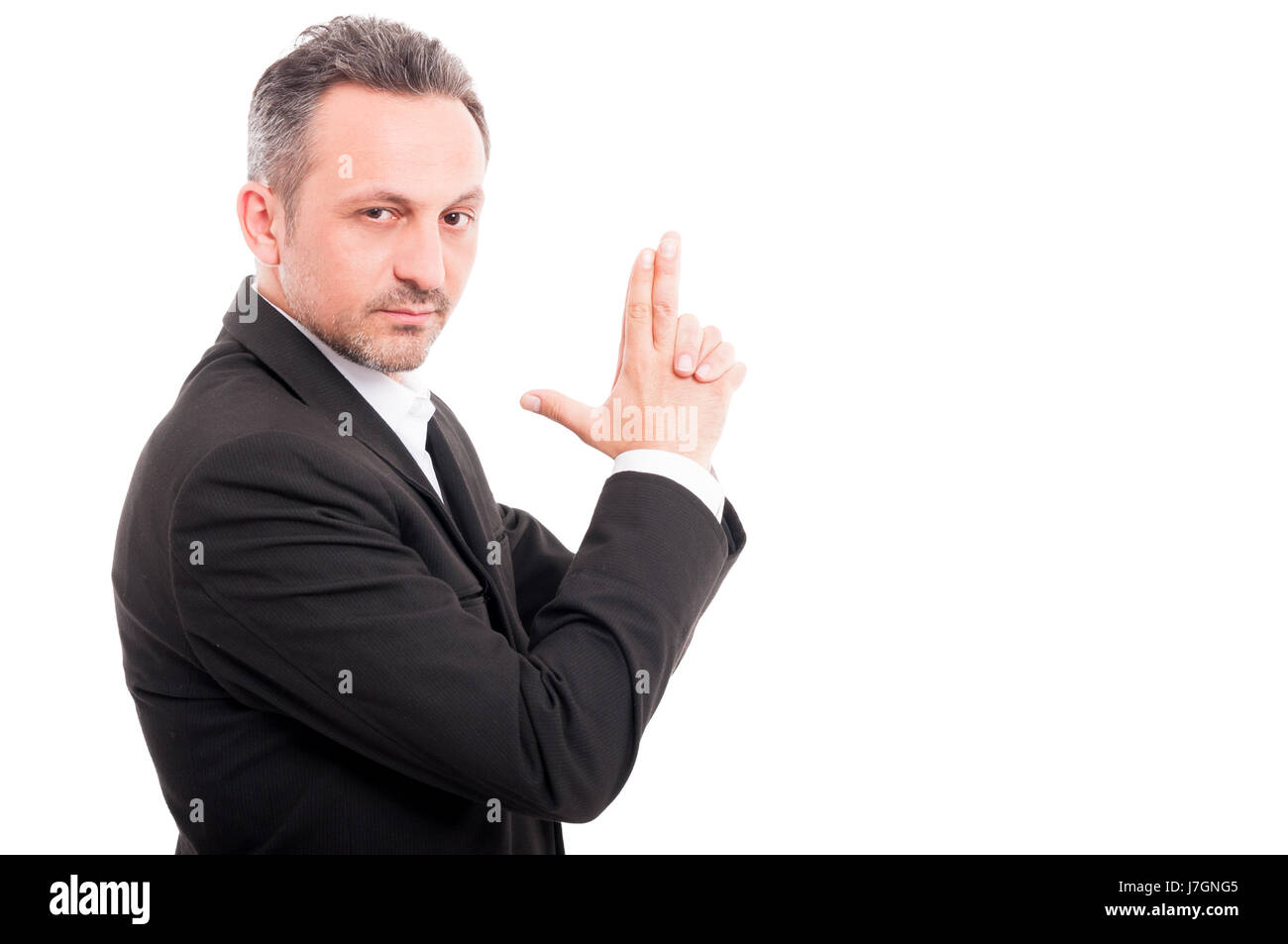 Businessman doing a gun gesture getting ready to shoot and acting like a secret agent isolated on white with text space Stock Photo