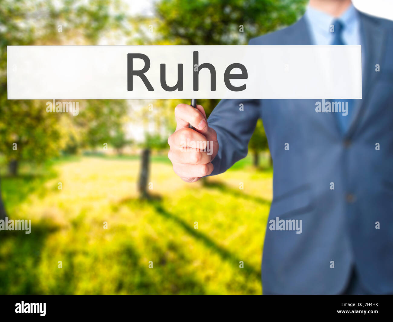 Ruhe (Quiet in German) Businessman hand holding sign. Business