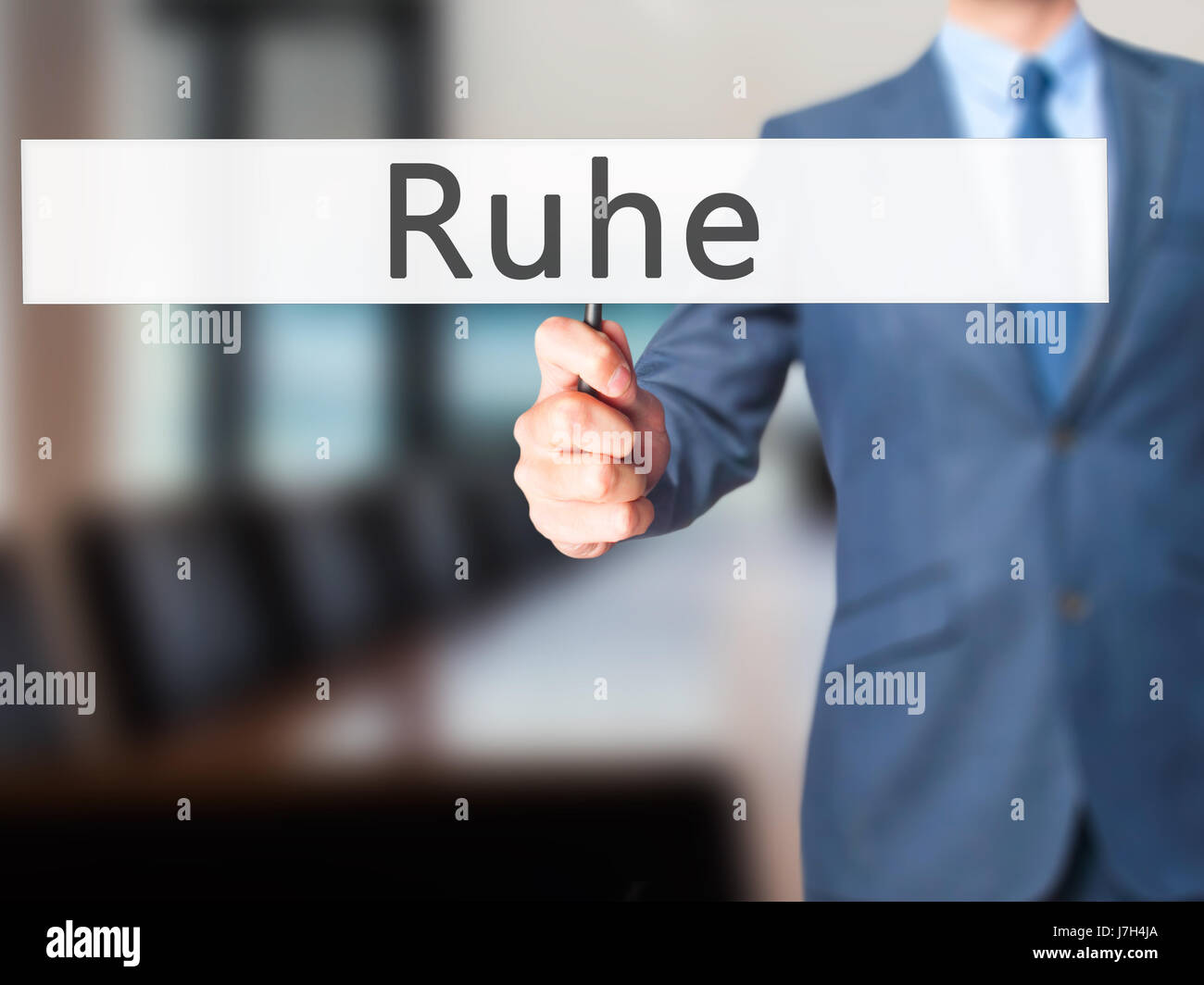 Ruhe (Quiet in German) Businessman hand holding sign. Business