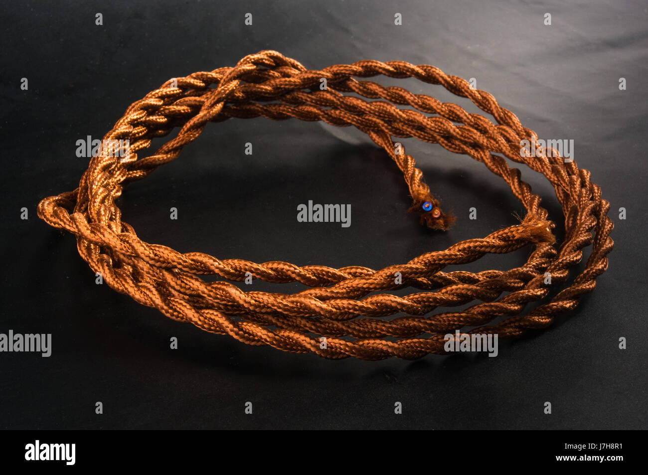 Electric cable in brown braid of fabric in retro style on black ...