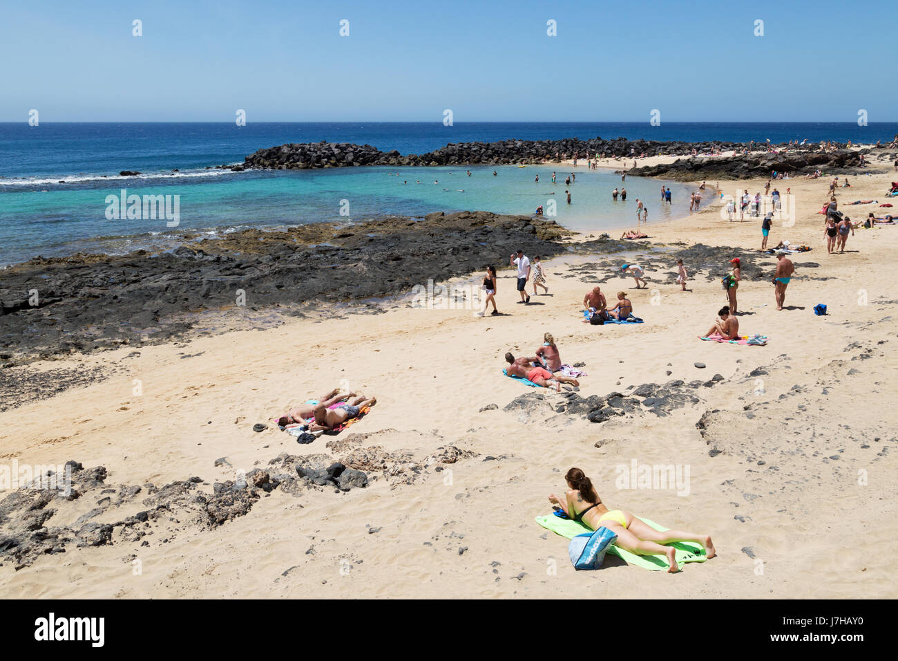 People sunbathing on a Lanzarote beach - Costa Teguise beach, Lanzarote, Canary Islands Europe Stock Photo
