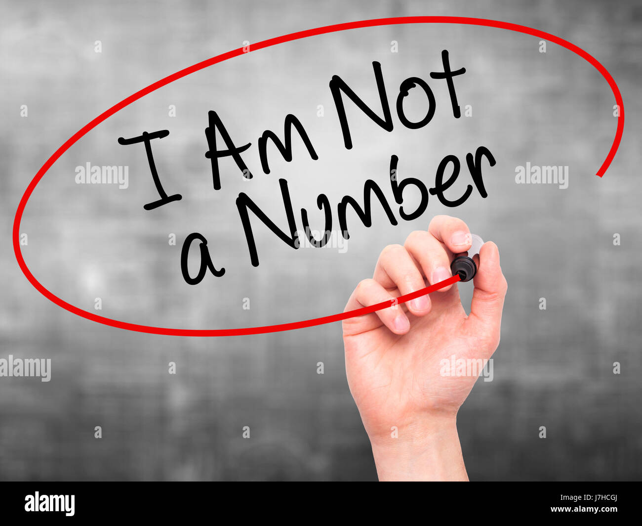 Man Hand writing I Am Not a Number with black marker on visual screen ...