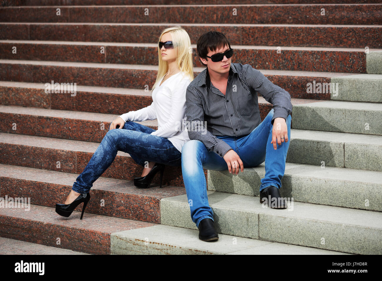Young couple in conflict sitting on the steps Stock Photo - Alamy