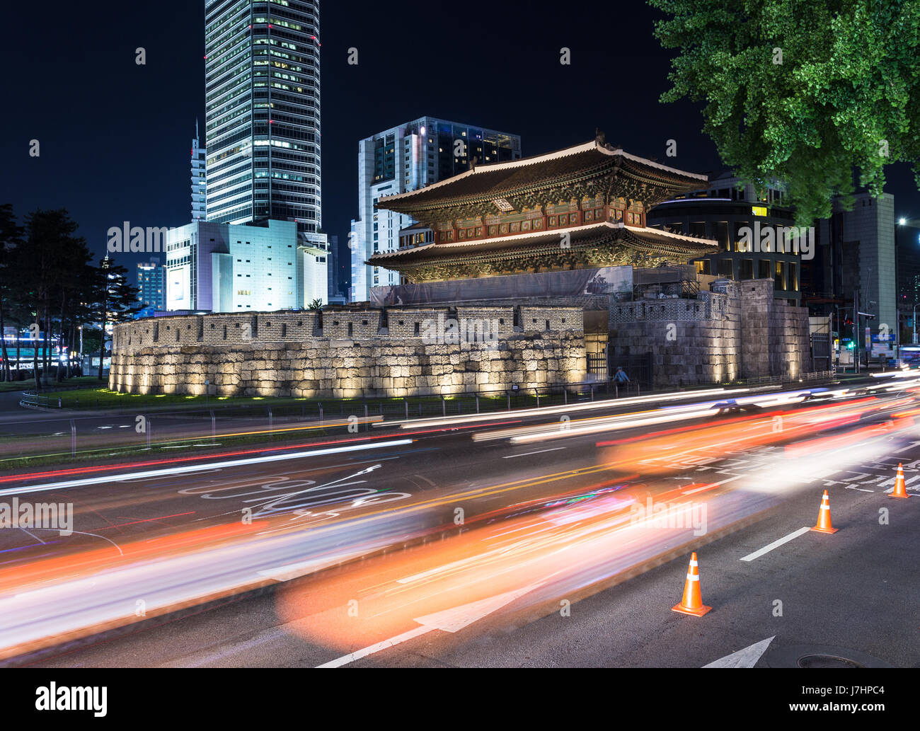 Traffic, captured with blurred motion, rushes around the Dongdaemun gate at night in Seoul, South Korea capital city. The gate was part of the Seoul c Stock Photo