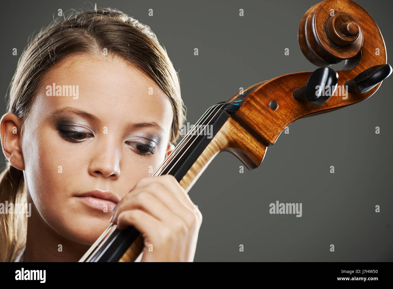 Close up portrait of a blond woman playing cello Stock Photo