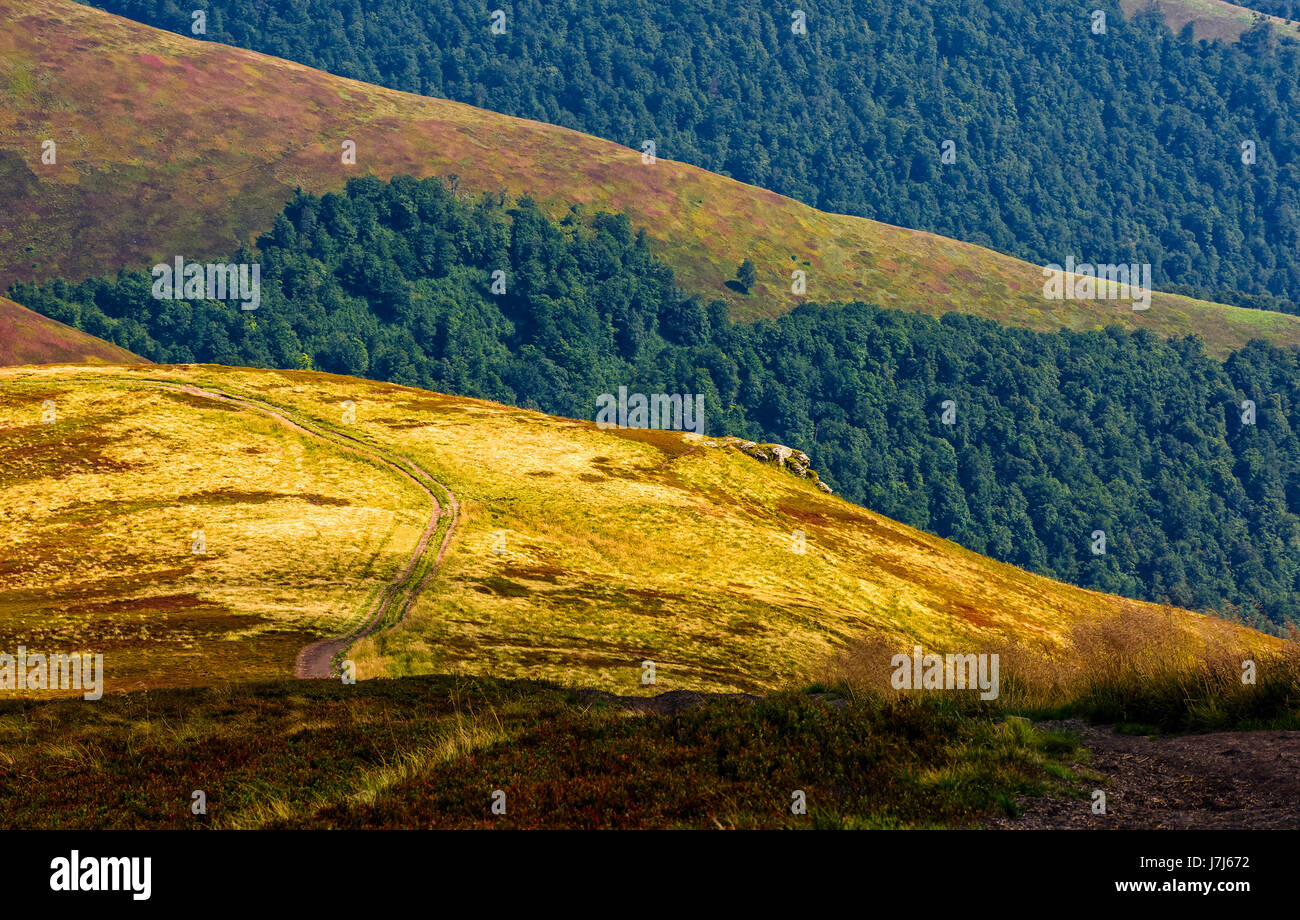 summer mountain landscape. path through the hill to the top. mountain ridge is seen in the distance Stock Photo