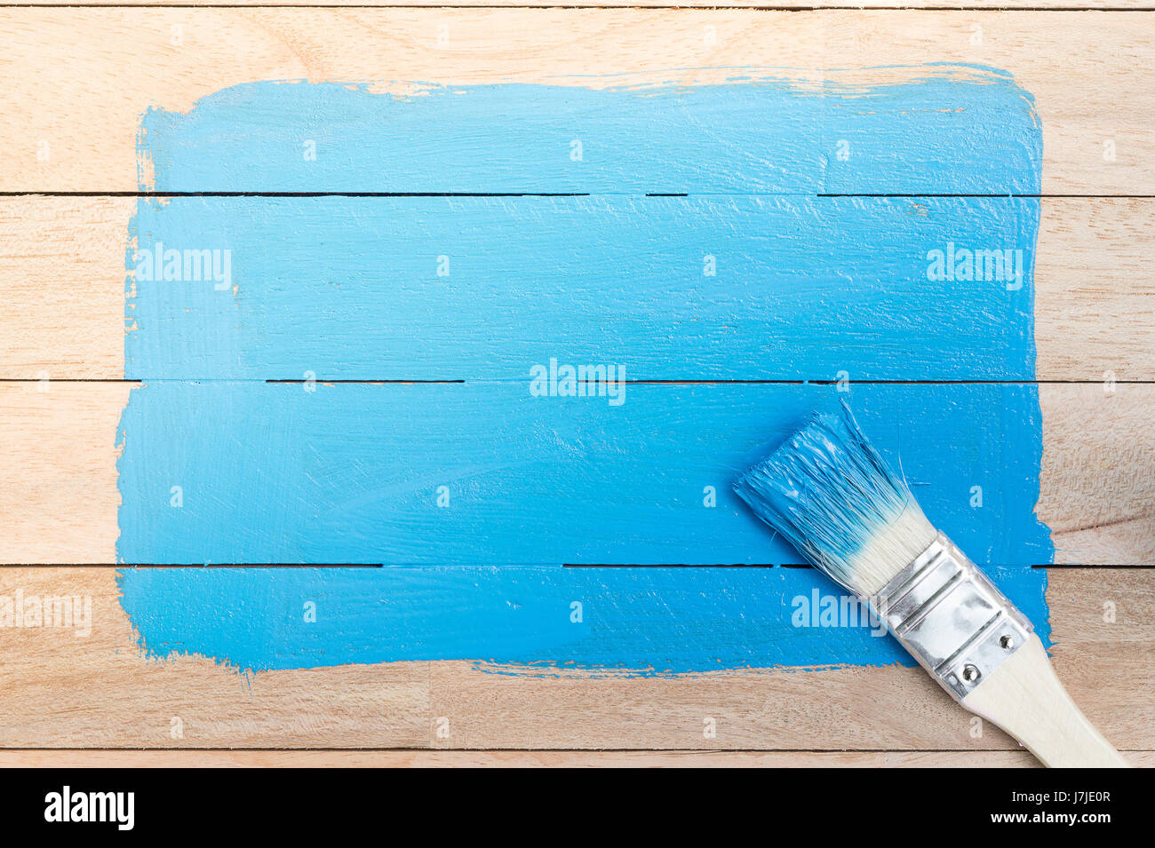 Blue paint space with paintbrush on wood background Stock Photo - Alamy
