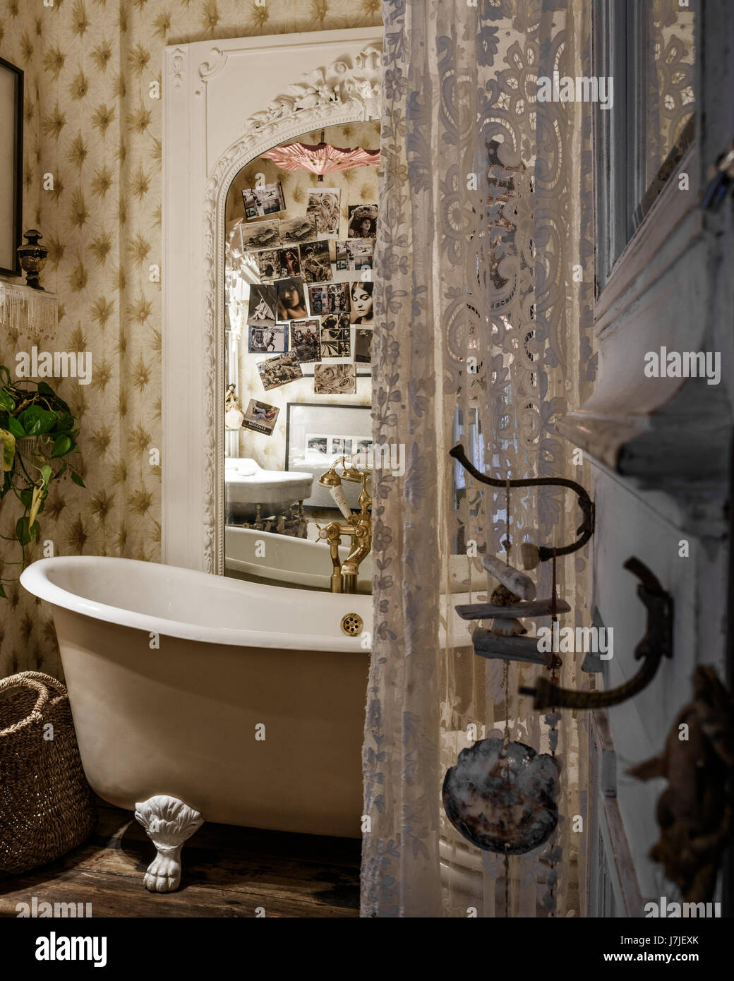 Ornate overmantel with lace fabric and claw-foot bath Stock Photo
