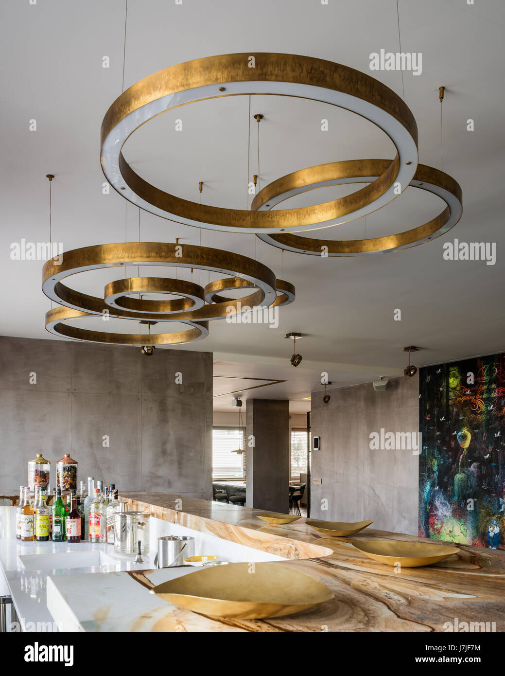 Circular brass light fittings above stonewood marble and onyx bar in Istanbul apartment Stock Photo
