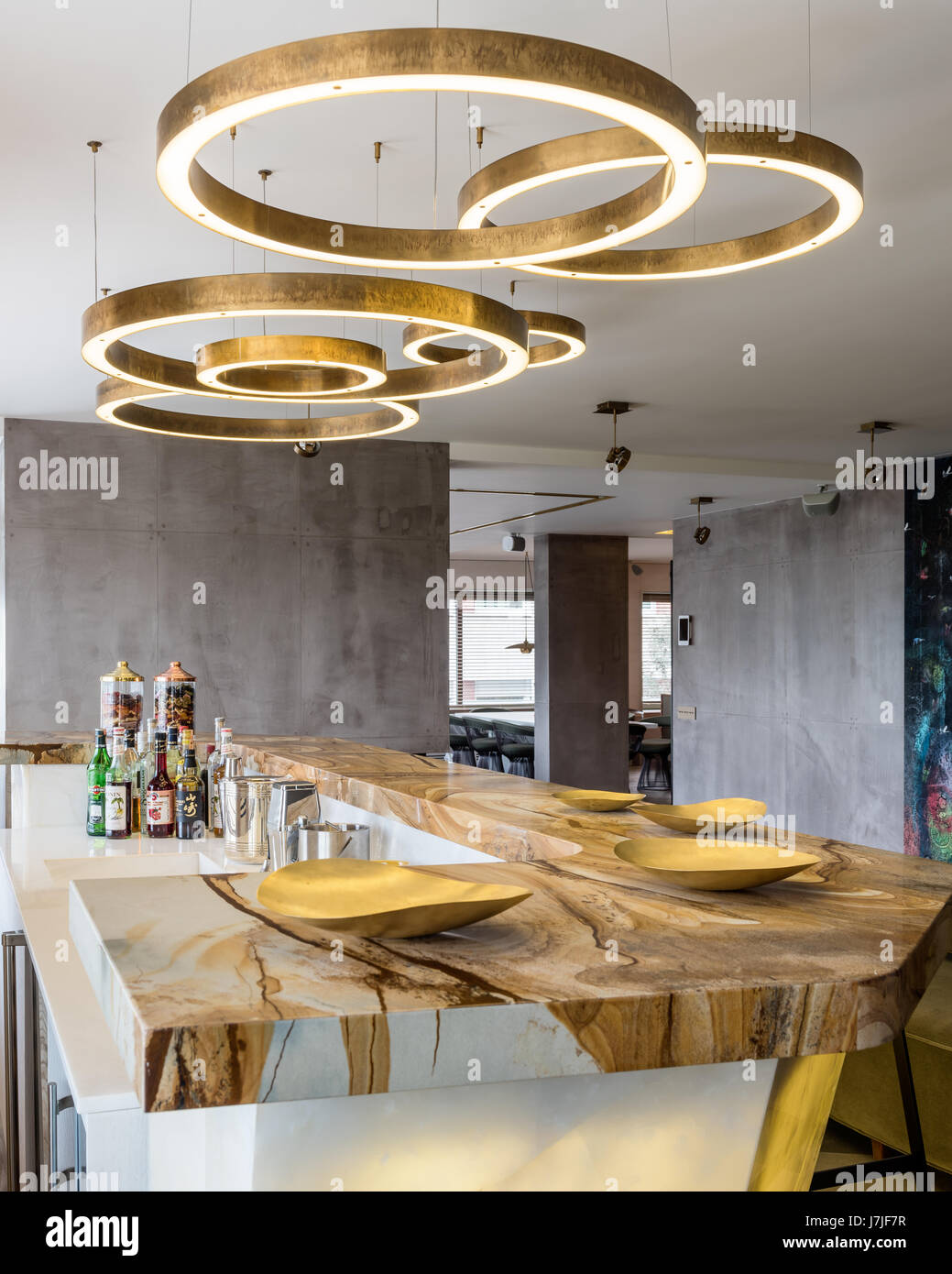 Circular brass light fittings above stonewood marble and onyx bar in Istanbul apartment Stock Photo