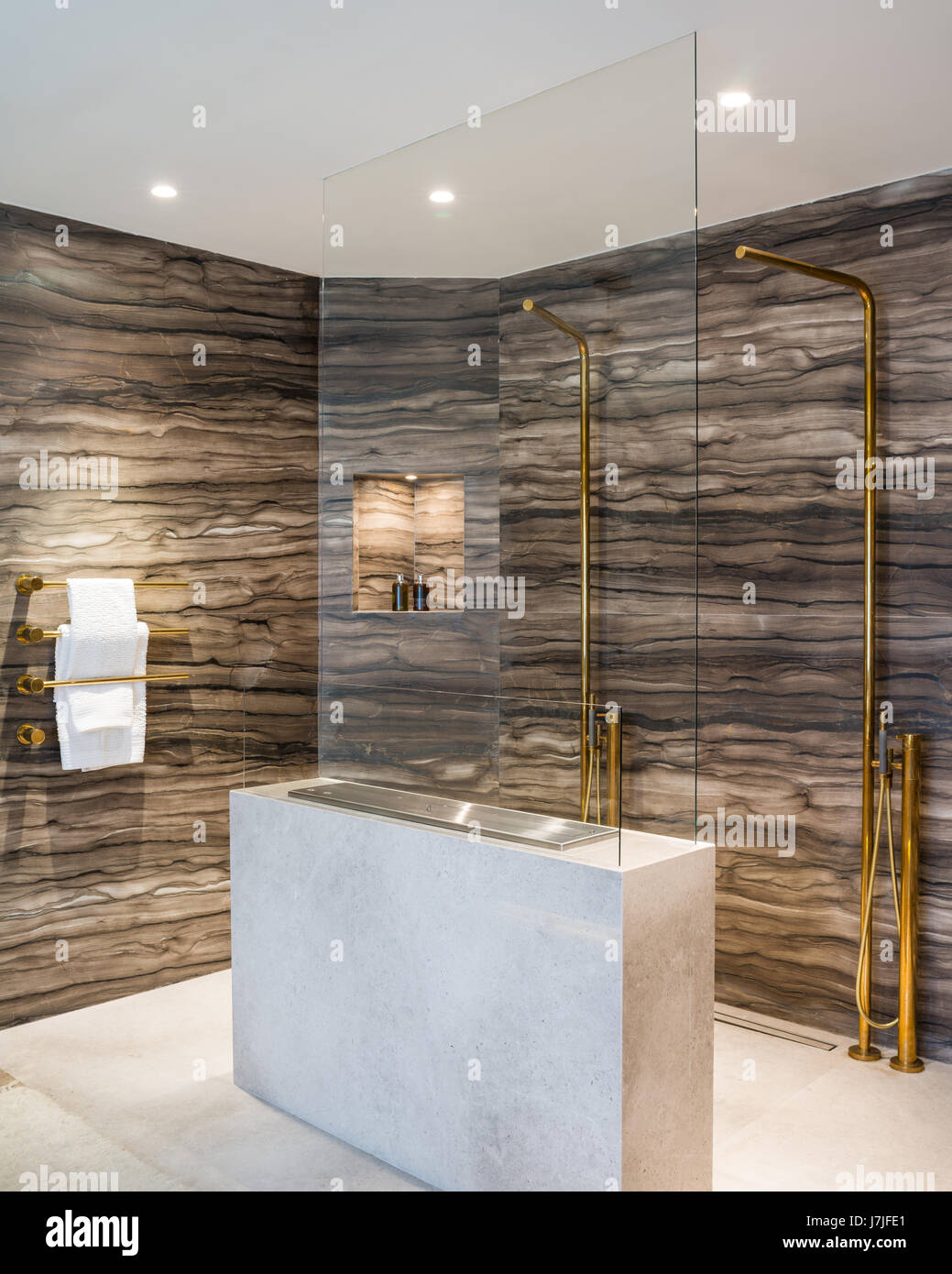 Sienna brown marble lines walls of shower area with gas fire Stock