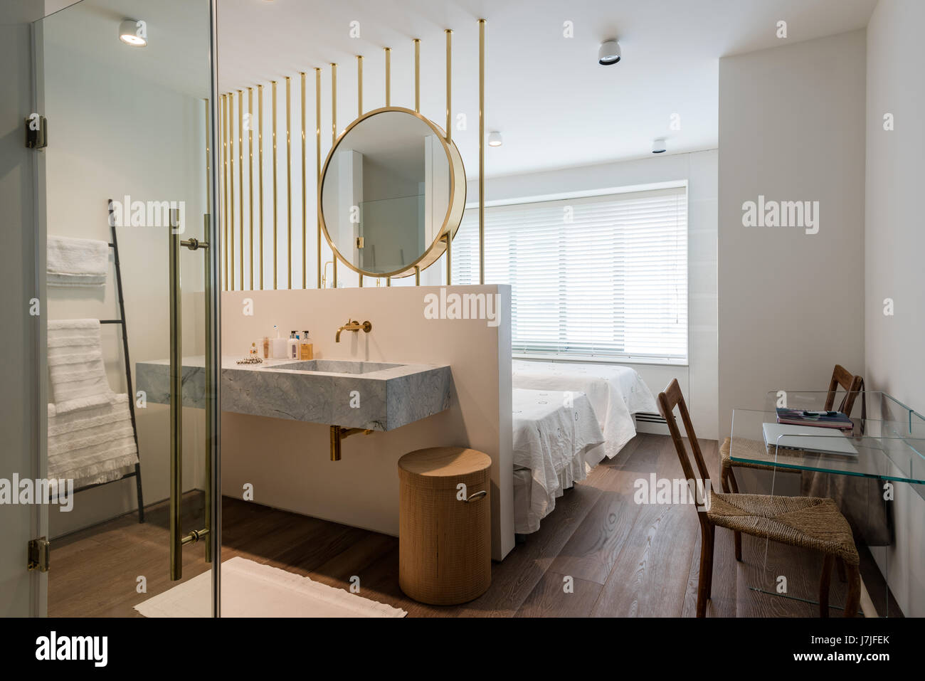 Large brass mirror above ensuite wash stand in twin bedroom Stock Photo