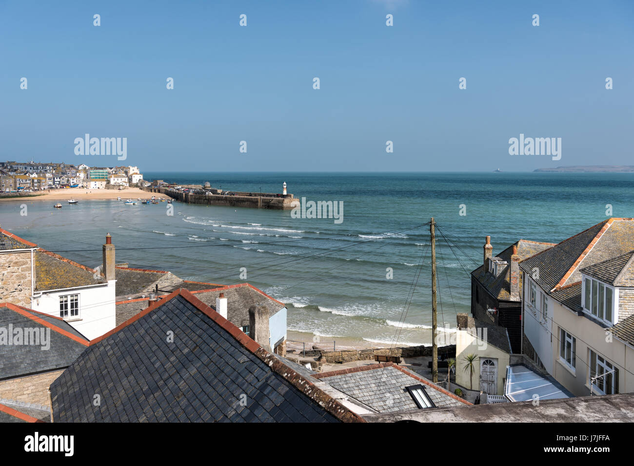 View over tiled roof tops over to St Ives harbour and the sea Stock Photo
