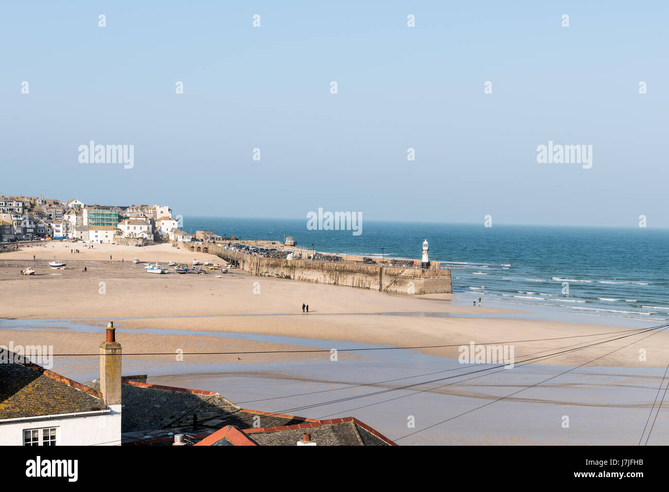 View over tiled roof tops of St Ives harbour and the sea Stock Photo