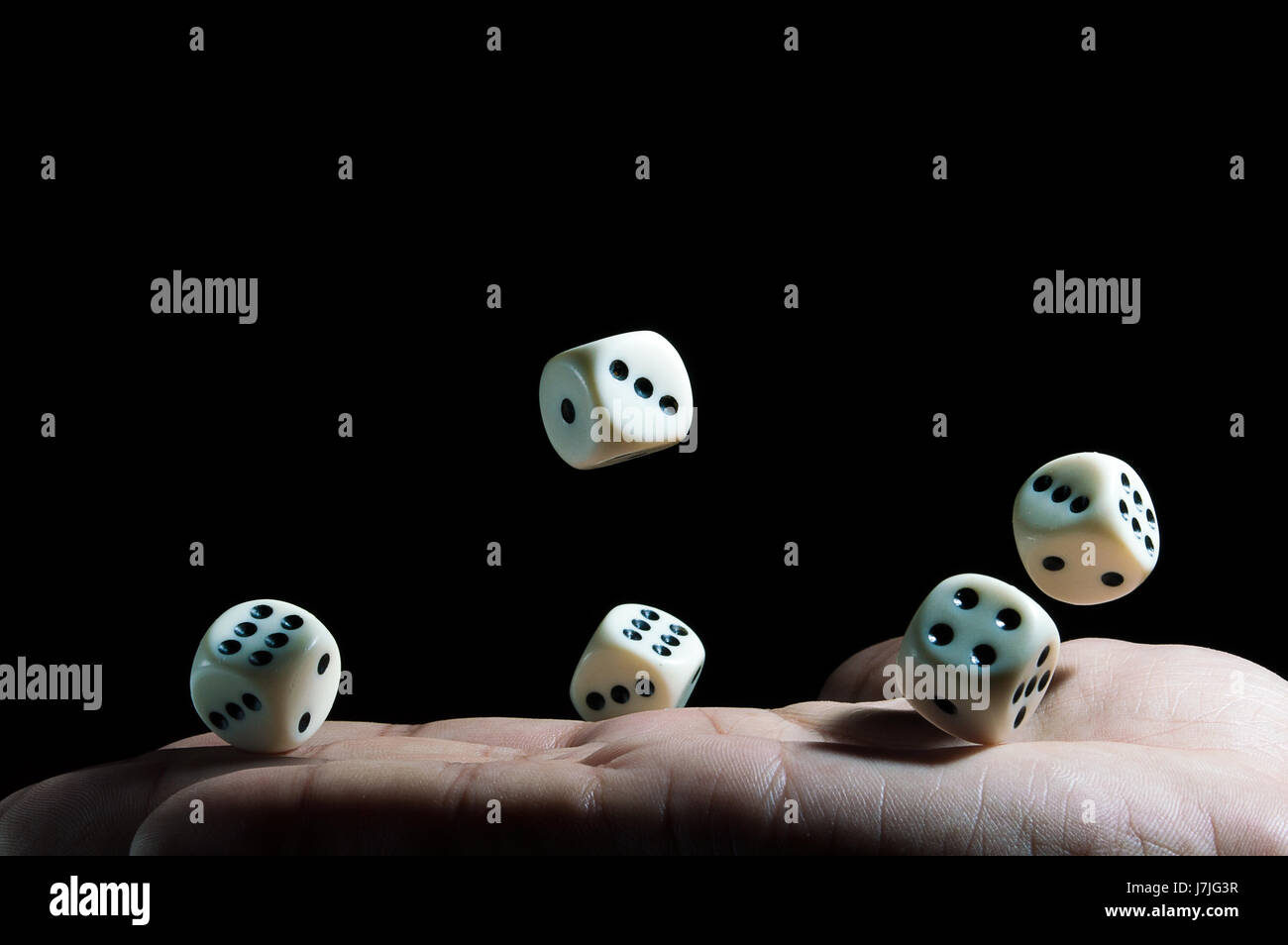 falling dice on the hand on black background Stock Photo