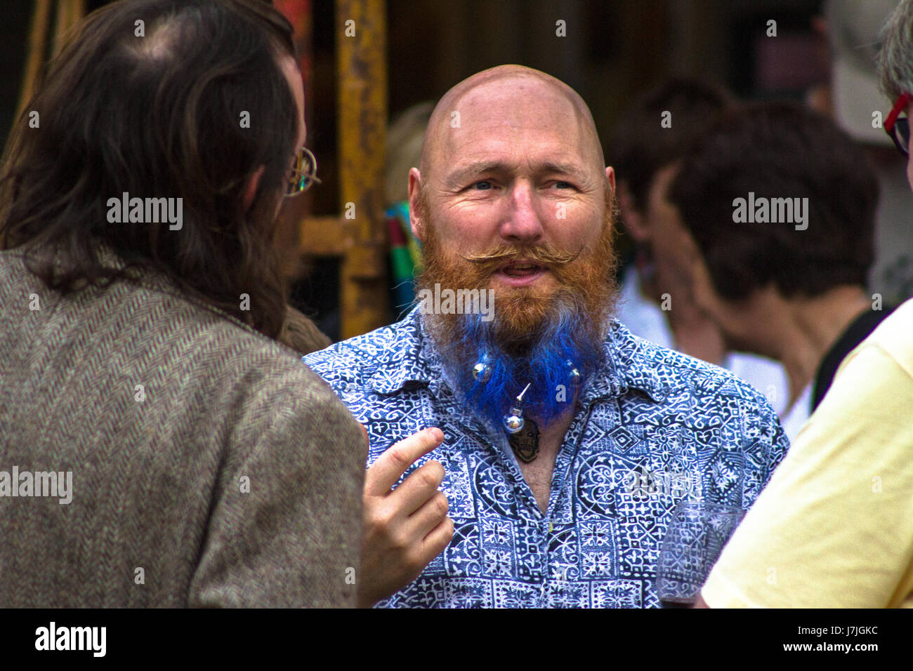 Bald, blue bearded man mid discussion at a festival in Castle Carrock, Cumbria, UK. Stock Photo