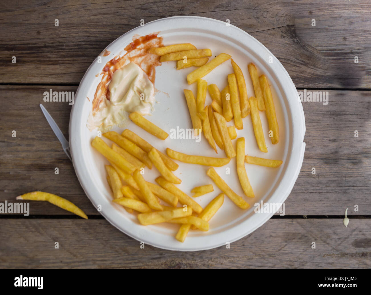 French fries, half eaten with ketchup and mayonnaise Stock Photo