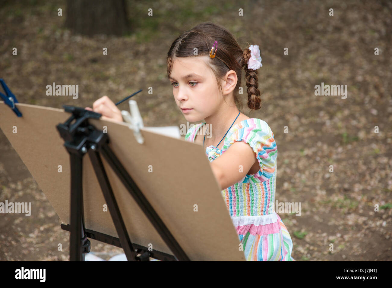 girl painting on easel in the park Stock Photo - Alamy