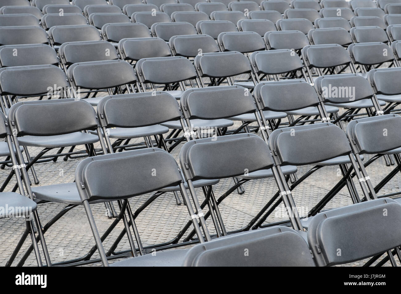 rows of empty chairs - black folding chairs Stock Photo