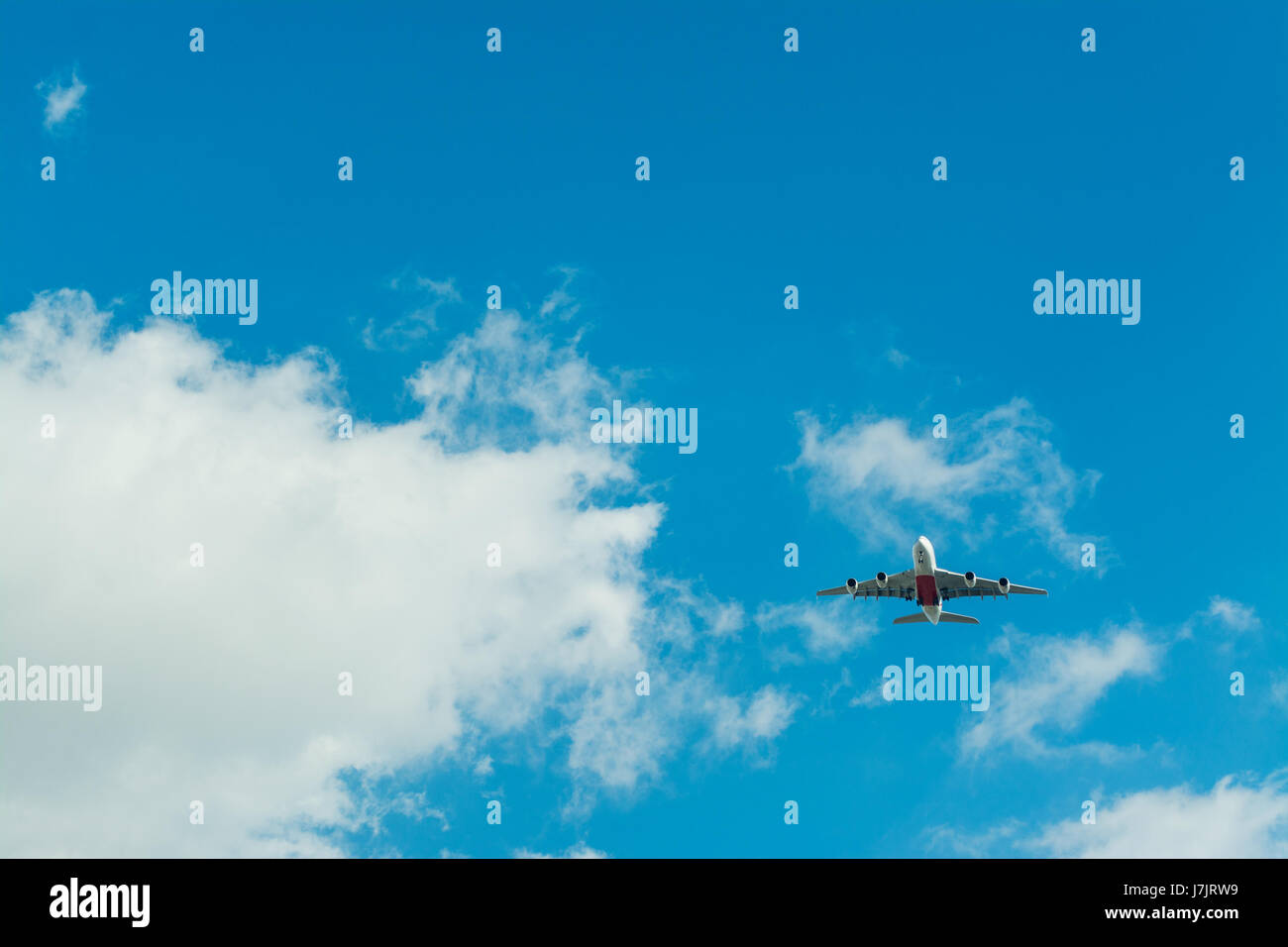 Airplane flying in a blue sky with clouds Stock Photo - Alamy