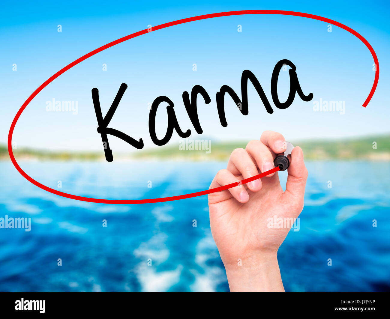 Man Hand writing Karma  with black marker on visual screen. Isolated on background. Business, technology, internet concept. Stock Photo Stock Photo