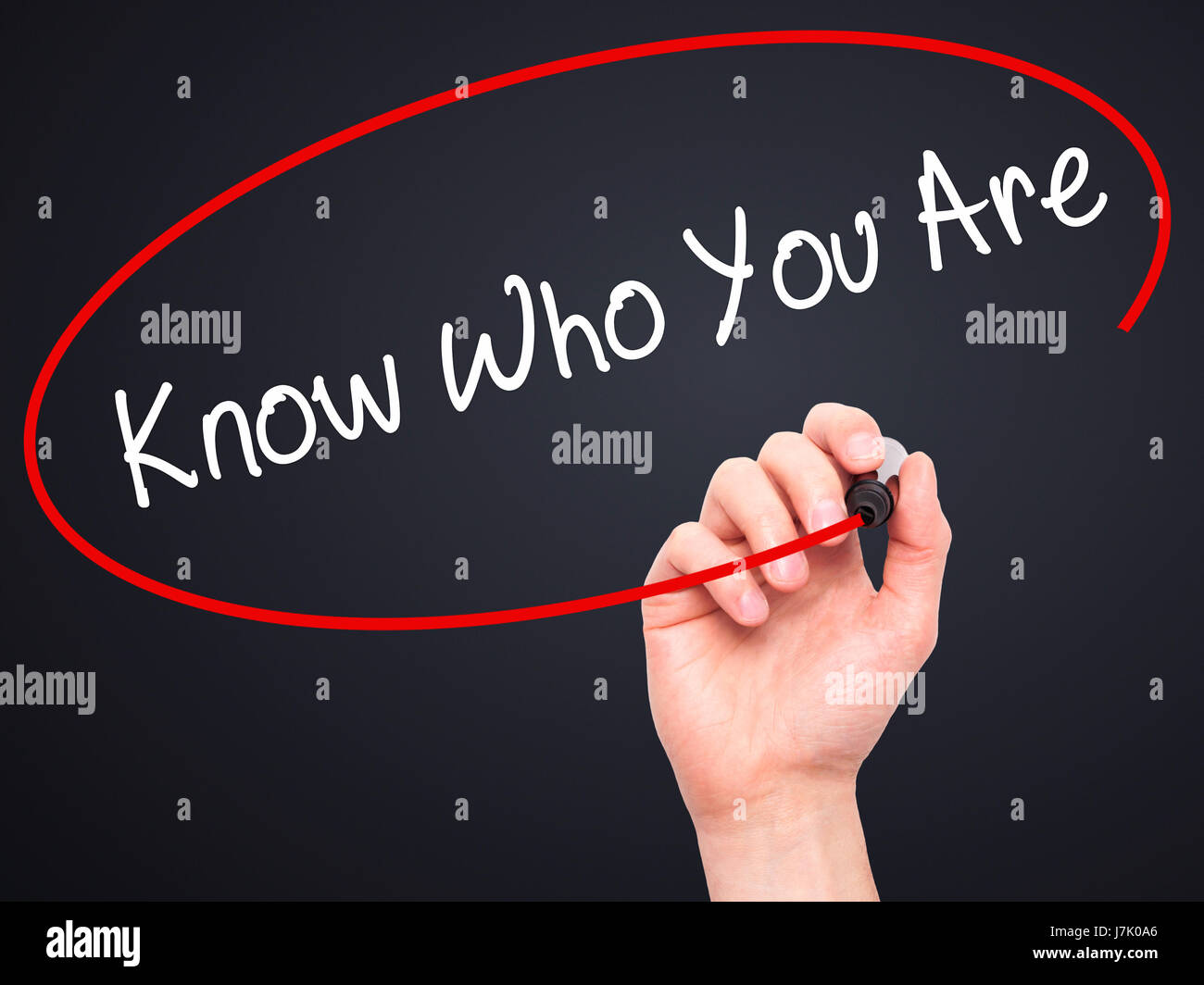 Man Hand writing Know Who You Are with black marker on visual screen. Isolated on black. Business, technology, internet concept. Stock Photo