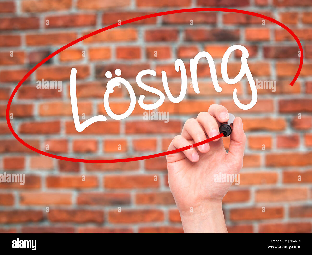 Man Hand writing Losung (Solution in German) with black marker on visual screen. Isolated on background. Business, technology, internet concept. Stock Stock Photo