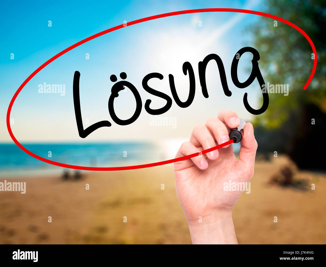 Man Hand writing Losung (Solution in German) with black marker on visual screen. Isolated on background. Business, technology, internet concept. Stock Stock Photo