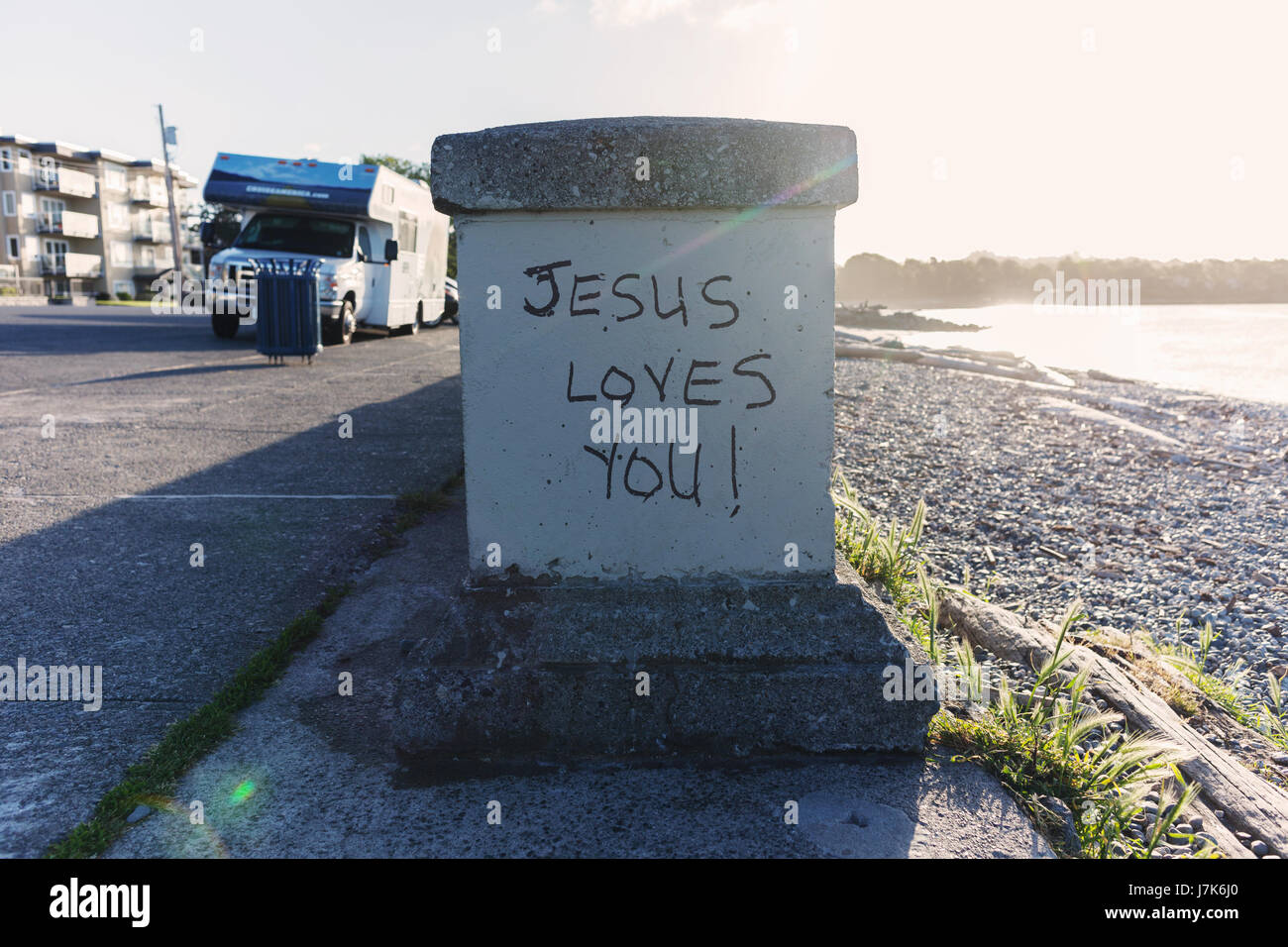 Jesus Loves You graffiti by the ocean.  Victoria, BC Canada Stock Photo