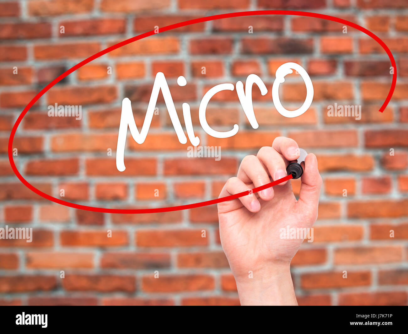 Man Hand writing Micro with black marker on visual screen. Isolated on background. Business, technology, internet concept. Stock Photo Stock Photo