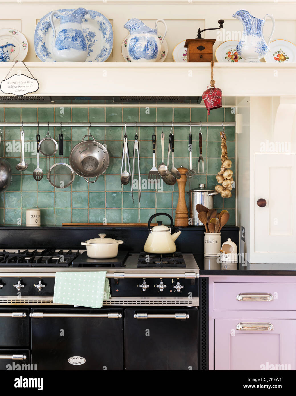 Chemin range cooker from Lacanche with sea green wall tiles and utensil rack. Stock Photo