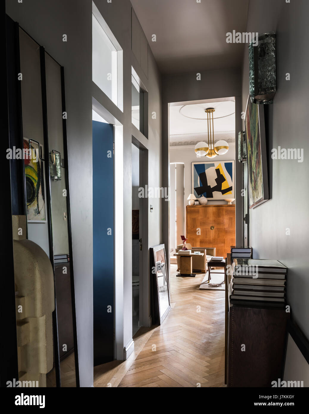 Modern art and books in hallway with parquet floor Stock Photo