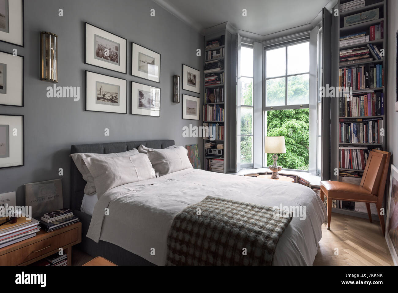 Calm grey tones and book shelving in bedroom with 1940s Murano glass