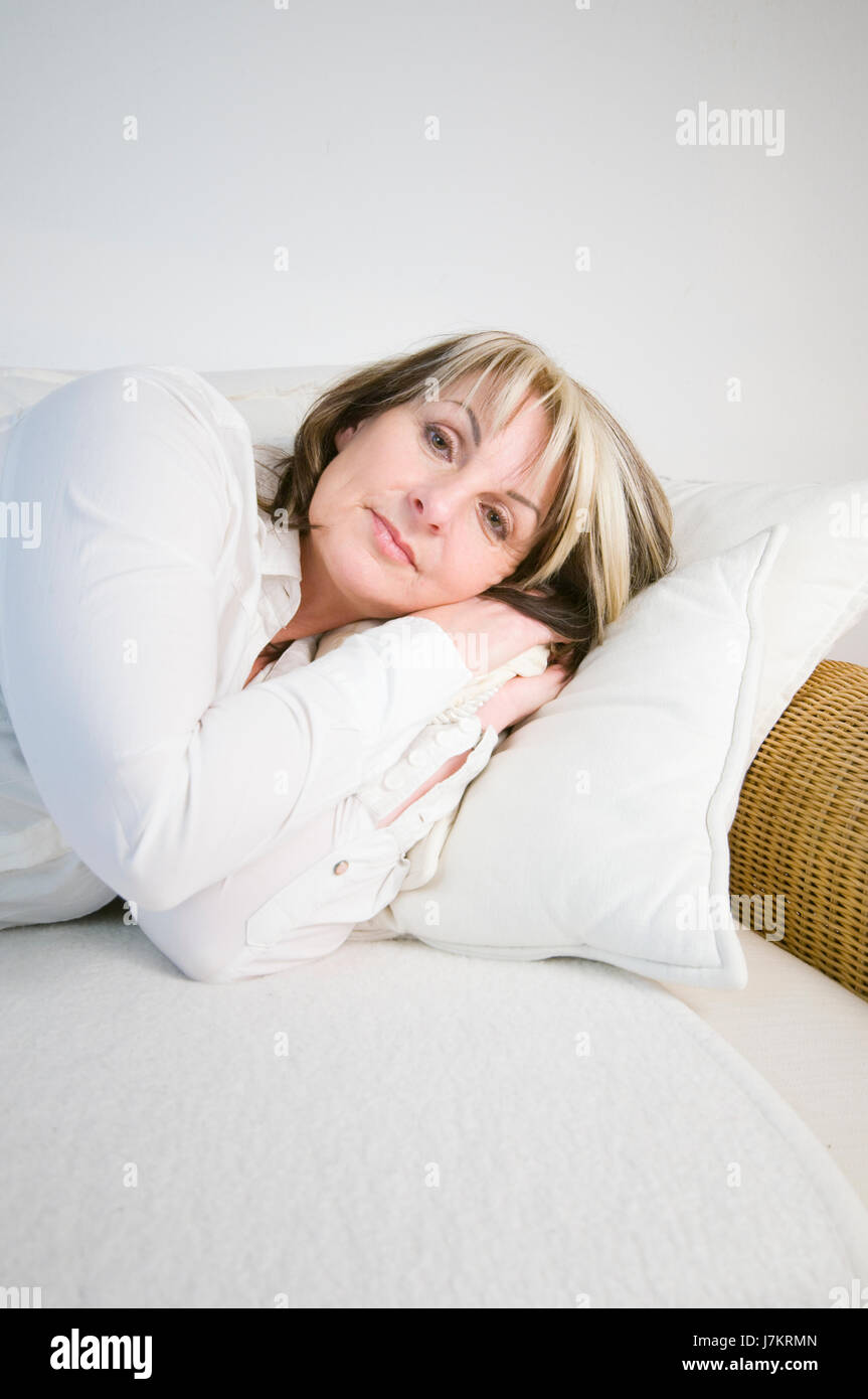 woman person lie lying lies adult couch woman laugh laughs laughing twit giggle Stock Photo
