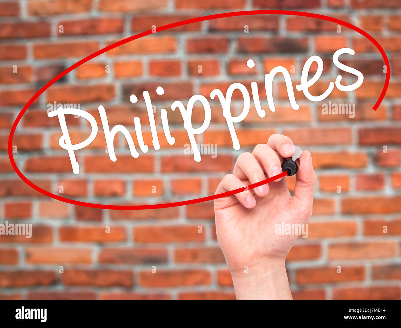 Man Hand writing Philippines with black marker on visual screen. Isolated on bricks. Business, technology, internet concept. Stock Photo Stock Photo
