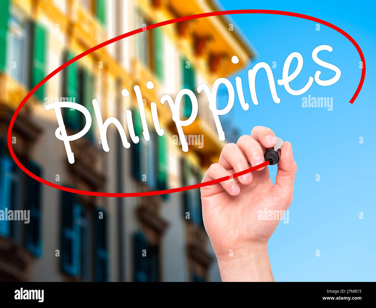 Man Hand writing Philippines with black marker on visual screen. Isolated on city. Business, technology, internet concept. Stock Photo Stock Photo