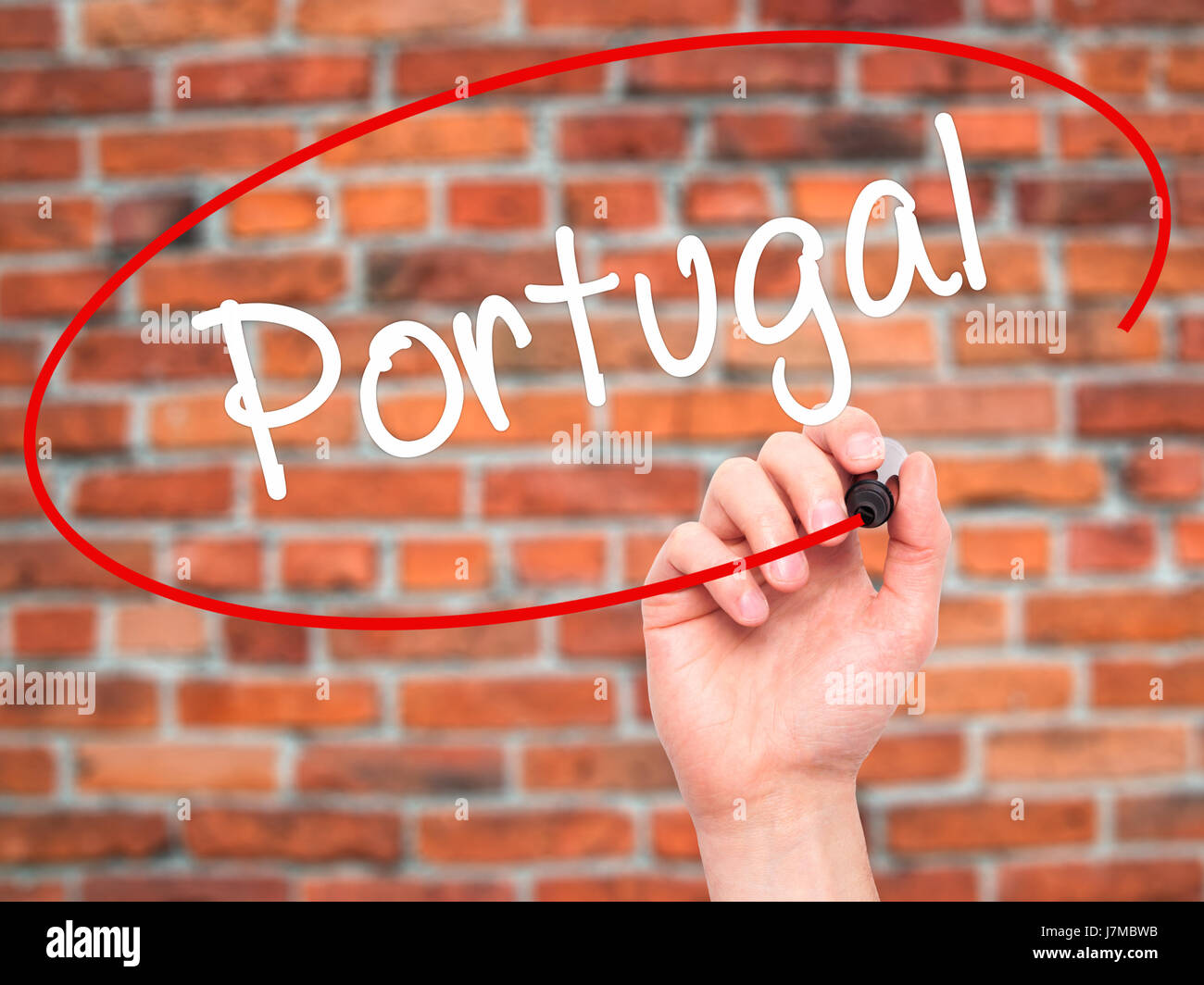 Man Hand writing  Portugal  with black marker on visual screen. Isolated on bricks. Business, technology, internet concept. Stock Photo Stock Photo