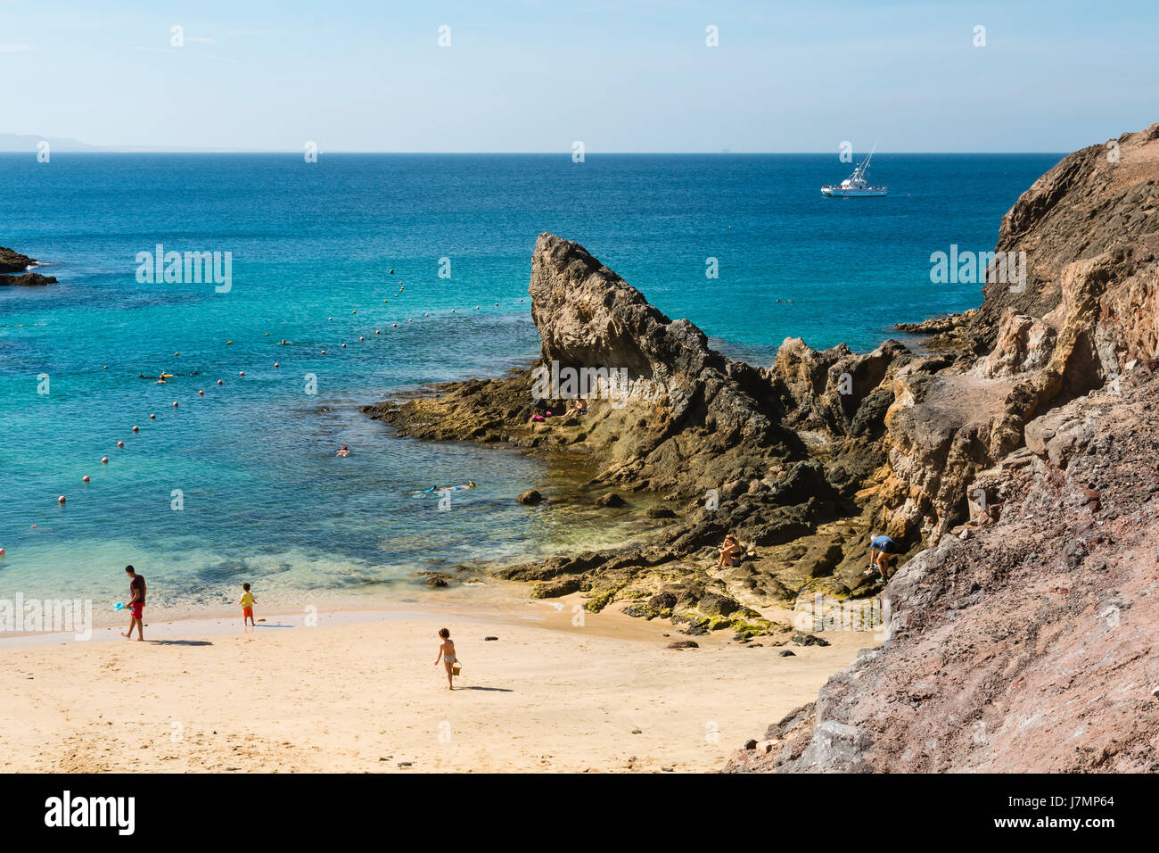 LANZAROTE - JANUARY 13: Tourists on the beautiful beach Playa de Papagayo in Lanzarote, Spain on January 13, 2016. Stock Photo