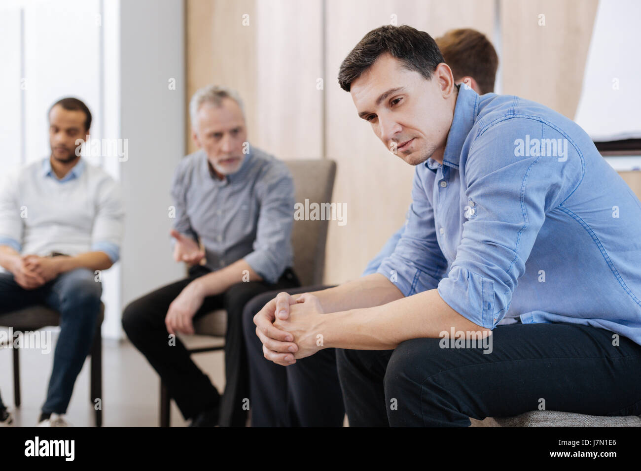 Nice thoughtful man sitting on the chair Stock Photo Alamy