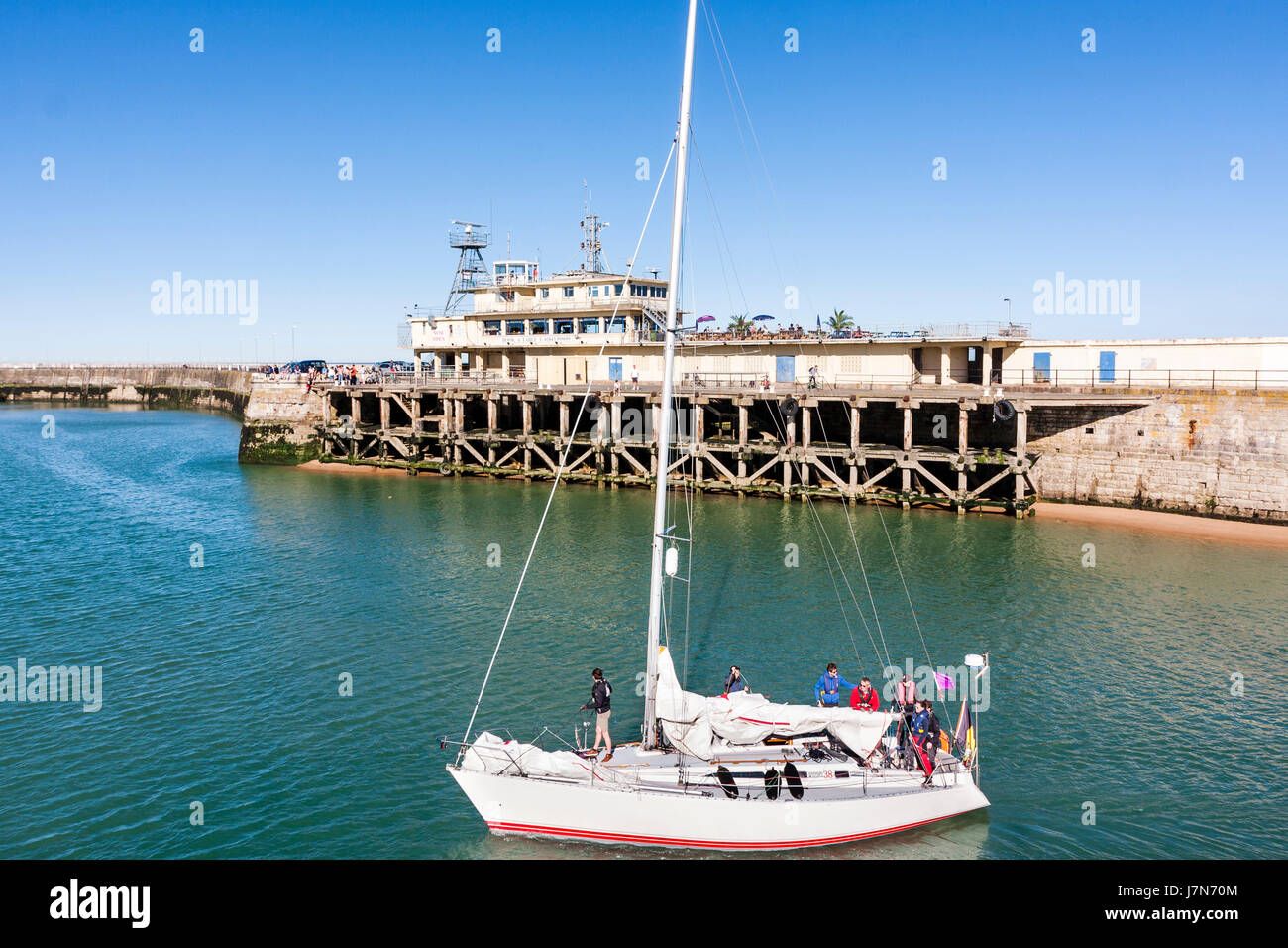Yacht sailing into Ramsgate harbour past the former harbour offices on