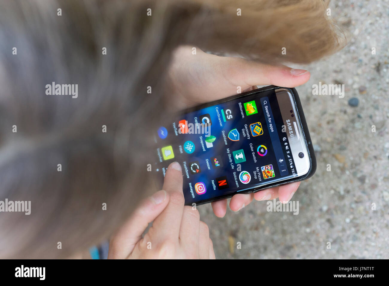 A girl using touchscreen mobile phone / smartphone apps Stock Photo