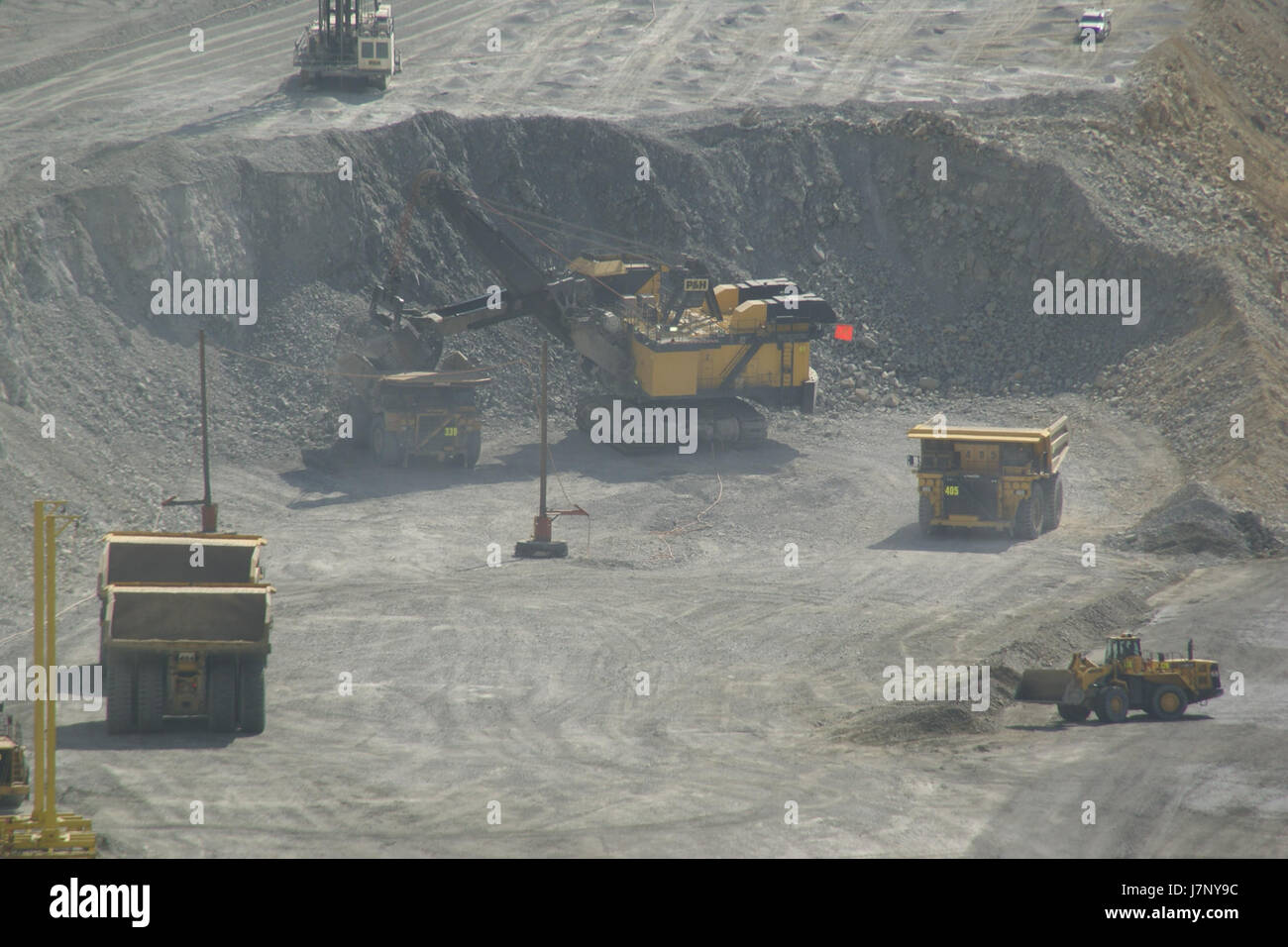 This photograph from September 29, 2012, captures trucks operating at the Bingham Canyon Mine in Utah, one of the largest open-pit copper mines in the world. The image highlights the mining operation, with large haul trucks transporting materials within the mine, a vital part of the mining industry. Stock Photo